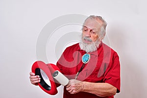 Strikingly dressed gentleman removing lint fron his red bowler hat