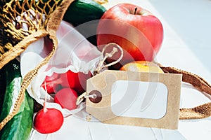 String bag with various fresh vegetables on white background