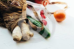 String bag with various fresh vegetables on white background