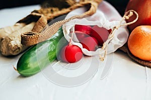 String bag with various fresh vegetables on white background