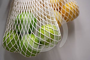 string bags with oranges and green apples, the concept of waste-free production