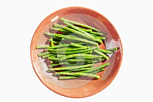 String beans on a pink plate. Diet vegetarian food. Top view. Isolated over white background