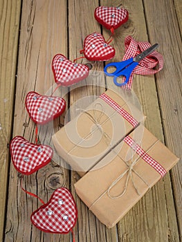 String and brown paper parcels with scissors, ribbon and hearts