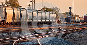 String of Bulk Tanker Railroad Cars in Railyard