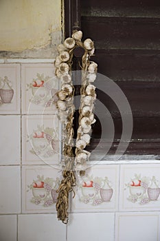 A string of garlic and onion hanging outside a house in Cuba