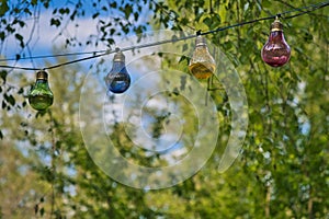 String of lights in bulb shape. Garden party or relaxing evening outdoors. Light mood with bokeh