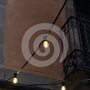 String of three bulb lights with balcony on the background - Image