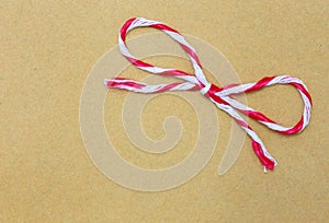 String tied in a bow, over brown paper