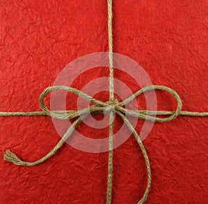 String tied in a bow on red paper