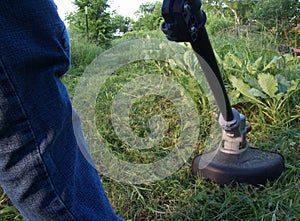 String trimmer mowing weeds