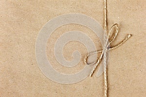 String or twine tied in a bow on kraft paper