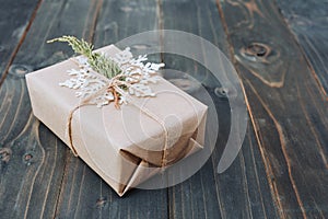 String or twine tied in a bow on kraft paper. Beown gift box on wood with space