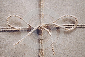 String or twine tied in a bow on kraft paper texture