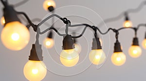 String of warm glowing light bulbs against a soft gray background, giving a cozy ambiance