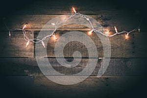 A String of White Lights on Aged Wood Background