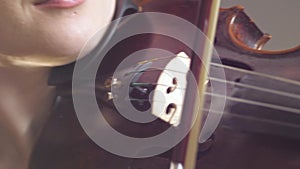 Stringed musical tool close up, violinist girl plays on wooden fiddle in studio