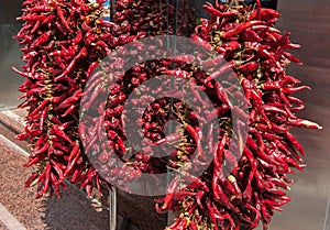 Strings Dried Red Hot Chili Peppers hanging outdoors