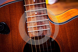 Strings on the fretboard of an acoustic guitar. Closeup