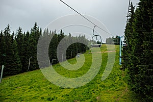 strings of a teleferic over a green mountain photo