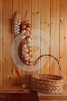 Strings of white onions and garlic with basket