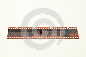 A strip of analog photographic film resting on an ivory background.