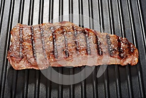 Strip loin steak on a grill