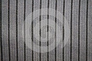 Stripe of black color on gray fabric background.