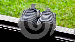 Striped baby boy shoe with blue and white on window sill photo
