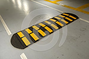 Striped black and yellow speed bump on a road