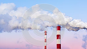 Striped chimneys emit thick white smoke in the evening blue pink sky. Air pollution, environmental problems. Tall pipes beautiful photo