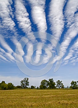 Striped clouds over the cleaned wheaten field