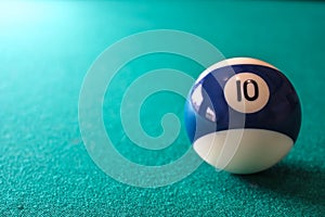 Striped color blue and white billiard ball with number 10 on green table background