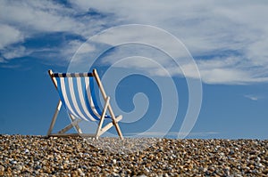Striped deckchair on pebble beach