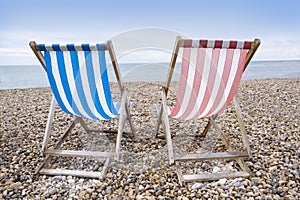 Striped deckchairs on pebble beach