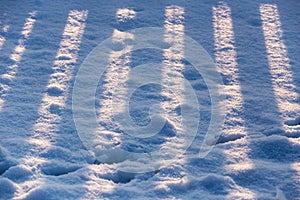 Striped fence shadow on snow