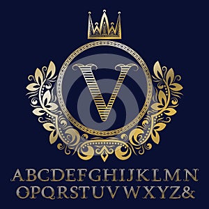 Striped gold letters and initial monogram in coat of arms form with crown. Royal font and elements kit for logo