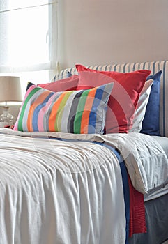 Striped headboard with Colouful pillows and striped pillow on white bed sheet photo