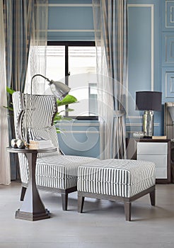 Striped high back armchair with ottoman in blue classic bedroom