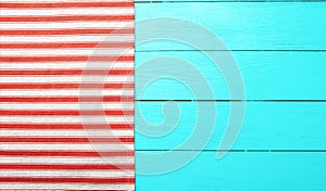 Striped napkin on blue wooden table. Top view of tablecloth and mock up. Copy space