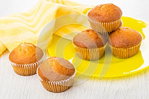 Striped napkin, small muffins in yellow plate and on table