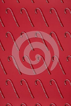 Striped red and white candy canes on red background. Cristmas lollipop. Trendy pattern Flat lay hard light