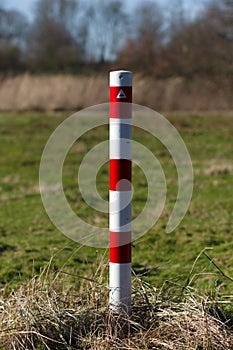 Striped red and white signal poles barricade