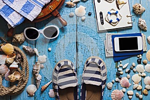 Striped slippers, phone and maritime decorations on the wooden b