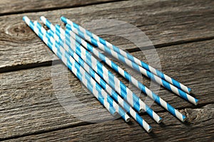 Striped straws for cocktails on grey wooden background.