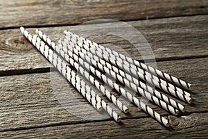 Striped straws for cocktails on grey wooden background.