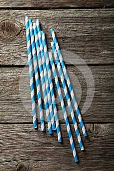 Striped straws for cocktails on a grey wooden background