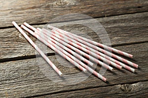 Striped straws for cocktails on a grey wooden background