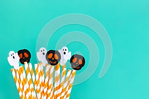 Striped straws with halloween elements on turquiose background