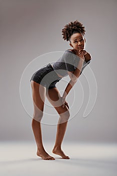 Striped top, thoughtful stance, woman stands reflecting