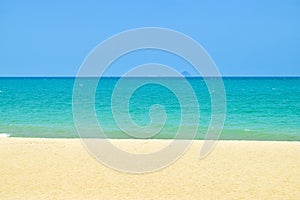 Stripes of blue sky and green ocean and yelllow sand on beach